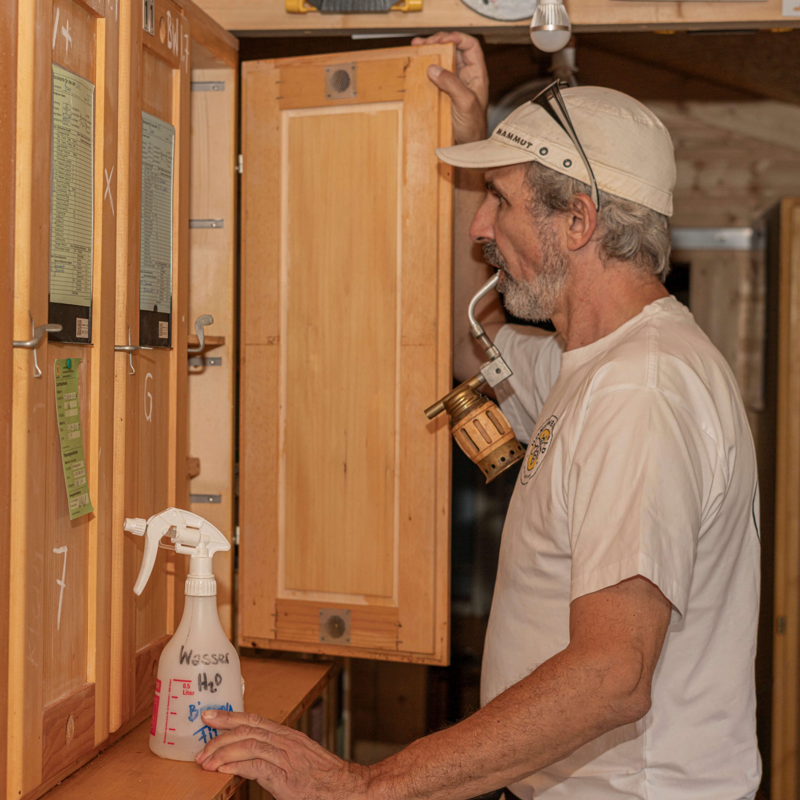 Raymond Held vor Bienenstock mit Imkerpfeife